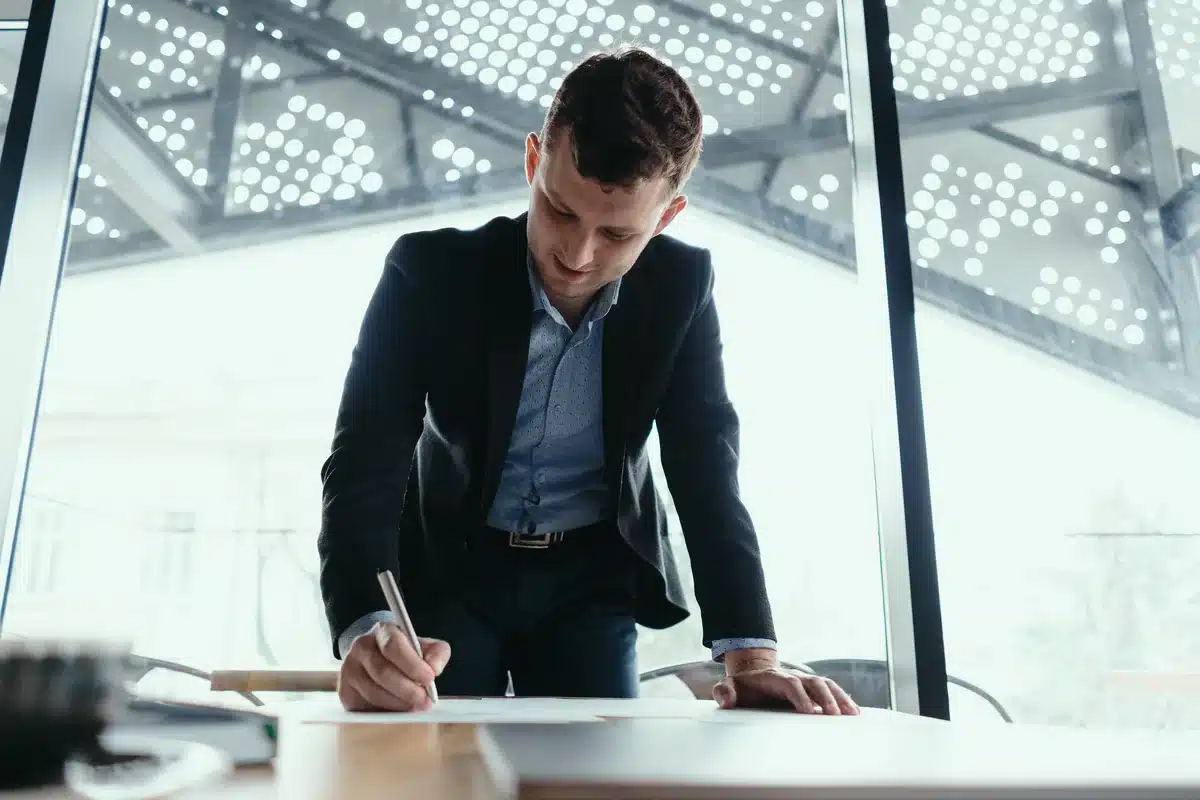 Business professional reviewing and signing documents at a desk