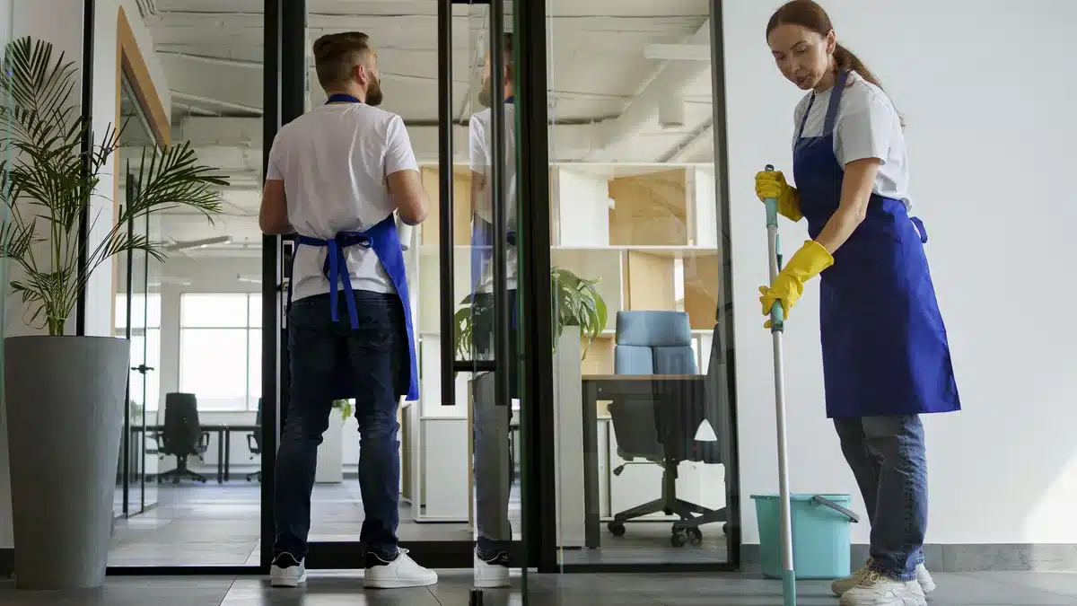 Two cleaning professionals coordinating work in an office